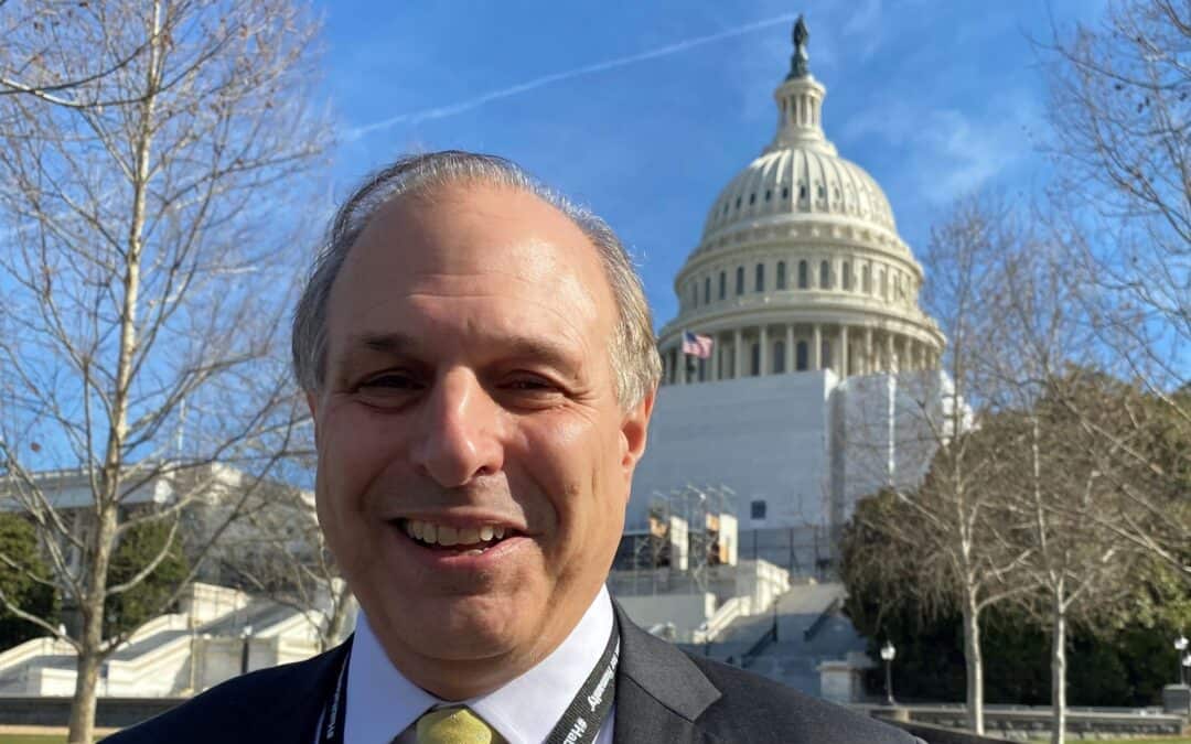 Jim Kostaras stands smiling in front of the U.S. Capitol